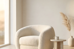 Modern white armchair in a minimalistic room with a small table and decorative elements.