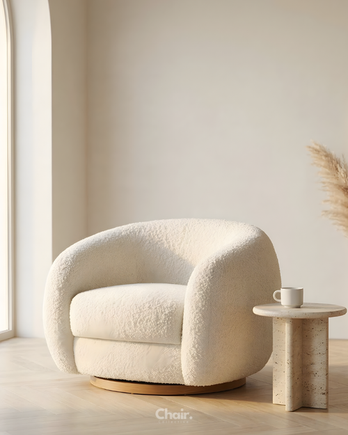 Modern white armchair in a minimalistic room with a small table and decorative elements.