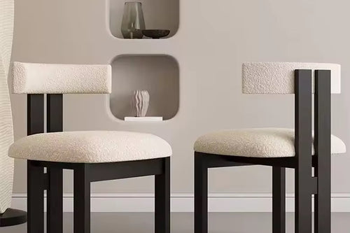 Two modern chairs with black frames and beige cushions.