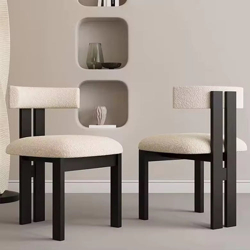 Two modern chairs with black frames and beige cushions.