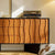 Wavy wood cabinet with matte black base.