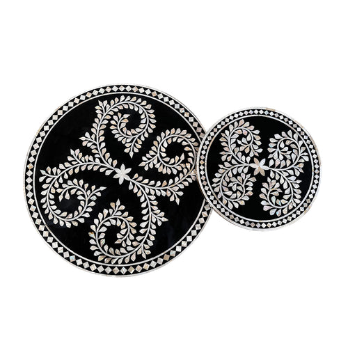 Two black circular coasters with white  on a white background