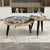 Two round side tables with black and gold designs 
