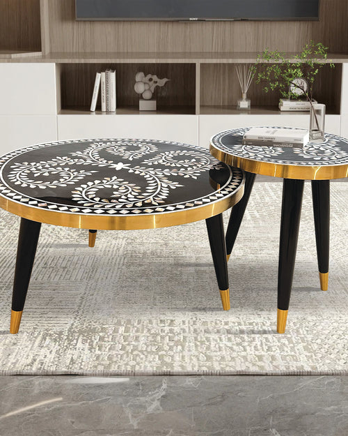 Two round side tables with black and gold designs 