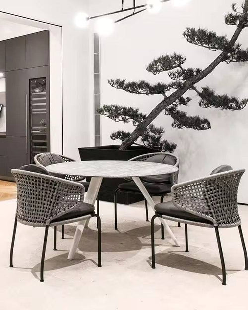 Brendon round marble table and wicker chairs in a stylish interior.