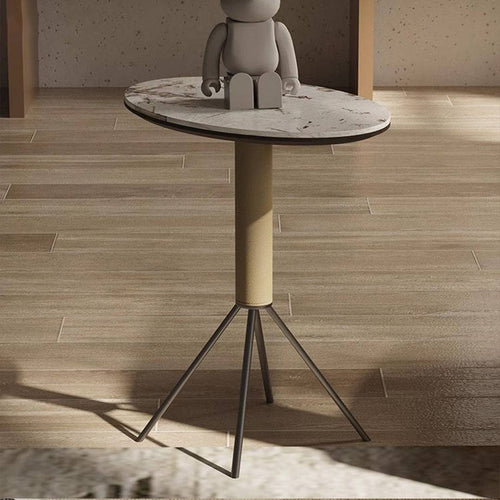 Small round table with a marble top and cylindrical base on a wooden floor.