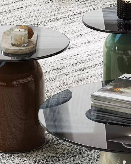 Three round glass tables in different colors