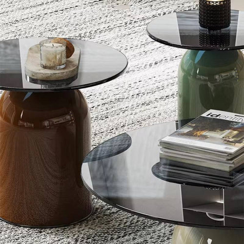 Three round glass tables in different colors