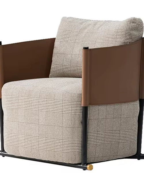 Gunter Accent Chair with a sleek metal frame and leatherite patch detailing, designed for modern luxury interiors with plush comfort and bold styling.