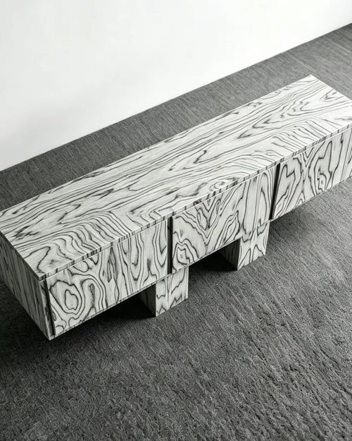 Harissa Console featuring a bold rectangular silhouette, sculptural veneered legs, and distinctive abstract wood grain flowing across the top and front.