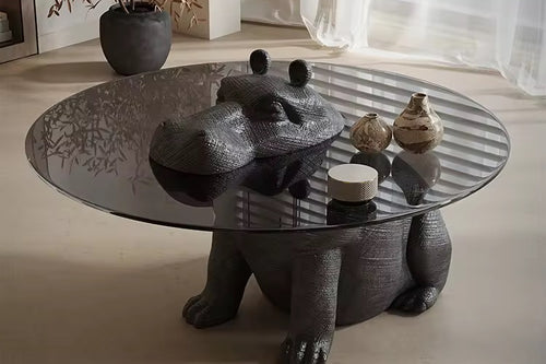 Modern coffee table with glass top and sculptural black bear base
