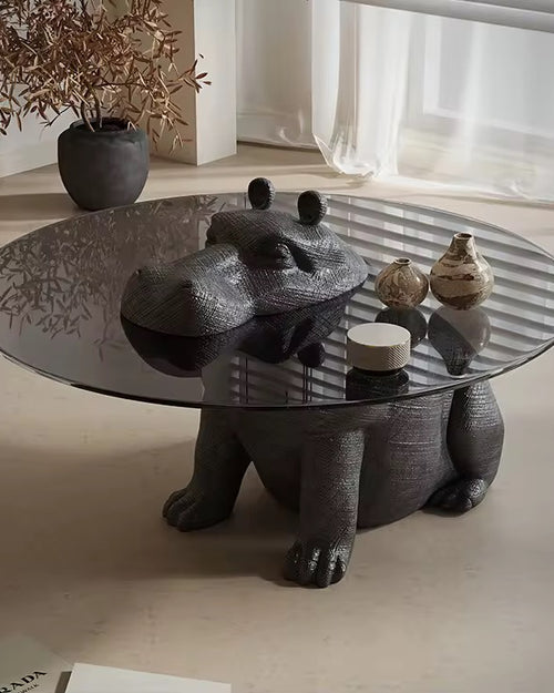 Modern coffee table with glass top and sculptural black bear base