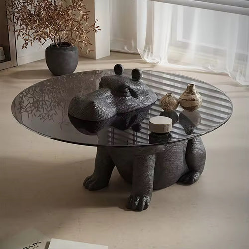Modern coffee table with glass top and sculptural black bear base