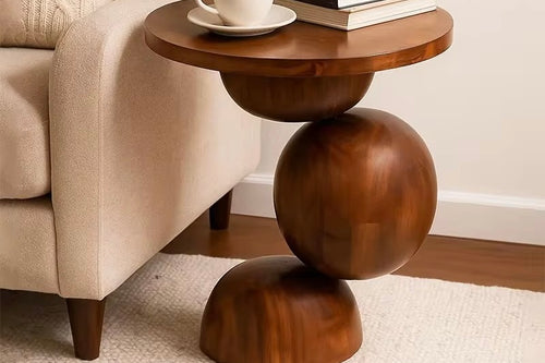 Sculptural end table crafted entirely from solid teak wood, featuring rounded geometric forms and a circular tabletop for contemporary luxury interiors.