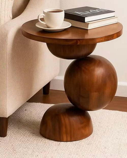 Sculptural end table crafted entirely from solid teak wood, featuring rounded geometric forms and a circular tabletop for contemporary luxury interiors.
