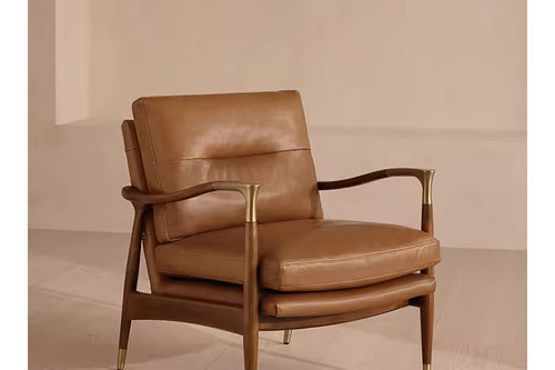 The Ember Chair embodies timeless sophistication, pairing buttery leather upholstery with a sleek, sculpted wooden frame. Gentle curves and slim armrests create an airy silhouette, while brass-capped legs add a note of refined luxury.