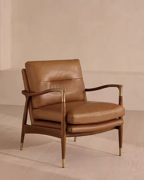 The Ember Chair embodies timeless sophistication, pairing buttery leather upholstery with a sleek, sculpted wooden frame. Gentle curves and slim armrests create an airy silhouette, while brass-capped legs add a note of refined luxury.