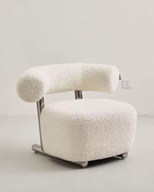 The Azure Chair is a striking blend of modern minimalism and tactile luxury. Its sculpted boucle seat wraps you in comfort, while the bold rolled backrest floats effortlessly above a sleek brushed steel frame.