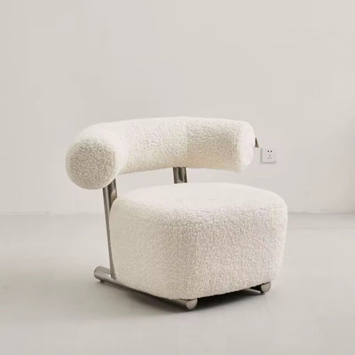 The Azure Chair is a striking blend of modern minimalism and tactile luxury. Its sculpted boucle seat wraps you in comfort, while the bold rolled backrest floats effortlessly above a sleek brushed steel frame.