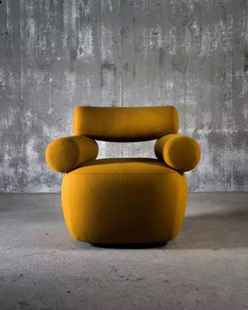 The Amalfi Chair redefines statement seating with its architectural silhouette and sculptural presence. Cylindrical arm bolsters and a contoured backrest create a harmonious balance between form and function, while the generous seat invites lingering moments of comfort.