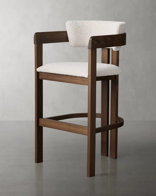 The Obelisk Chair is a celebration of geometry and structure—crafted with precision to bring architectural poise into everyday living. Its strong wooden frame and sculpted backrest create a grounded silhouette, while the bouclé upholstered seat and back add a tactile softness, balancing strength with comfort.