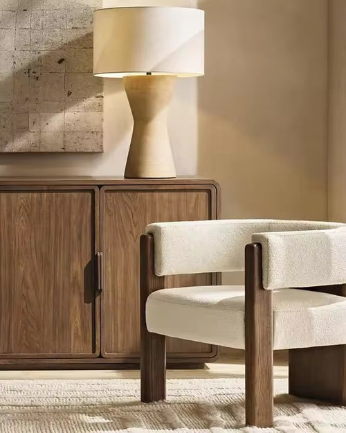 The Orion Chair embodies a perfect interplay of geometry and comfort, designed to be both sculptural and inviting. Its bold wooden legs rise seamlessly into the frame, grounding the design with architectural strength, while the plush bouclé upholstery wraps the seat and backrest in understated luxury.