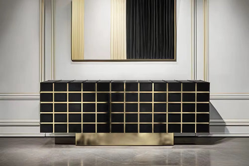 The Marbella Console is a striking fusion of modern design and opulent finishes. Featuring sleek black surfaces with golden accents, this console adds depth and sophistication to any interior. Its geometric pattern is elevated with polished golden lines that bring an architectural elegance to the piece, while the spacious storage compartments inside ensure practicality without compromising on style. Crafted for upscale living spaces, Marbella is perfect for adding a refined touch to living rooms, dining are
