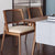 Discover the Daisy Dining Chair – modern retro seating in teak or white wood with cane backrest. Perfect as a dining chair or café chair online in India