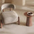 Curved beige chair with wooden legs