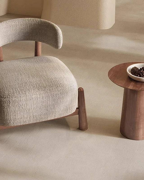 Curved beige chair with wooden legs