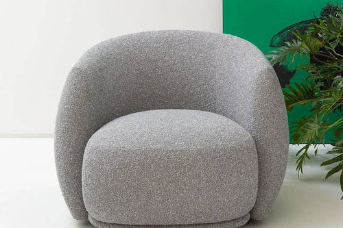 A gray oversized, round bucket chair with plush cushioning