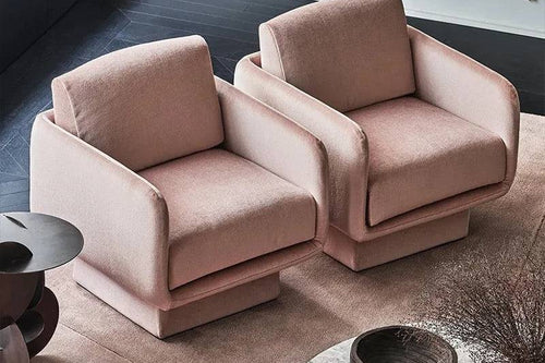 A pair of pink upholstered chairs with a modern design