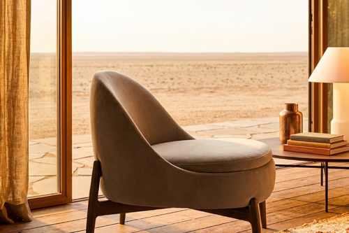 Elegant accent chair featuring a sculptural solid wooden base, curved backrest, and plush bouclé or leatherette upholstery designed for contemporary luxury interiors.