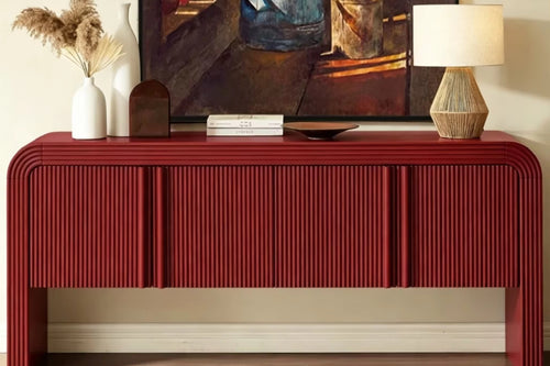 Bold red statement console featuring intricate fluted detailing, rounded edges, concealed storage, and a sculptural contemporary silhouette.