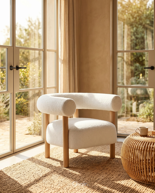 A sculptural Japandi-style accent chair upholstered in ivory bouclé fabric with a rounded backrest and solid wooden cylindrical legs.