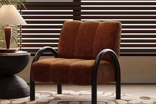 Brown cushioned chair with arched legs.