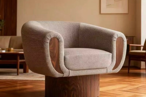 The Tura Accent Chair is a refined blend of sculptural form and tactile comfort, designed to make a quiet yet confident statement in contemporary interiors. Defined by its softly curved silhouette, the chair features a teak-finished base and sculpted teak arms, seamlessly integrated with plush upholstery to create a piece that feels both grounded and inviting.