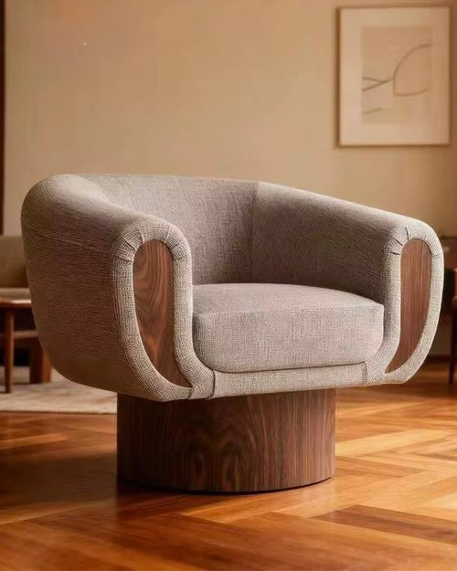 The Tura Accent Chair is a refined blend of sculptural form and tactile comfort, designed to make a quiet yet confident statement in contemporary interiors. Defined by its softly curved silhouette, the chair features a teak-finished base and sculpted teak arms, seamlessly integrated with plush upholstery to create a piece that feels both grounded and inviting.