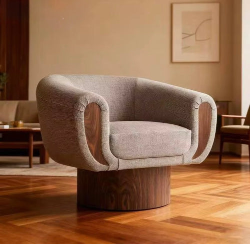 The Tura Accent Chair is a refined blend of sculptural form and tactile comfort, designed to make a quiet yet confident statement in contemporary interiors. Defined by its softly curved silhouette, the chair features a teak-finished base and sculpted teak arms, seamlessly integrated with plush upholstery to create a piece that feels both grounded and inviting.