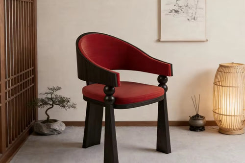 Yondu Dining Chair featuring a curved red upholstered seat and back, sculptural wooden arms, and a dark wood frame designed for contemporary dining spaces.