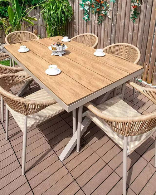 Wooden outdoor dining table with six wicker chairs