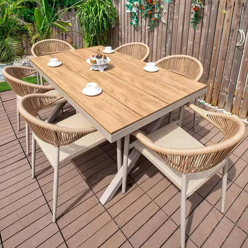 Wooden outdoor dining table with six wicker chairs