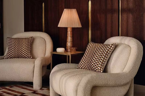Two beige armchairs with patterned cushions